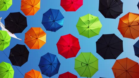 Malta,-Zabbar,-umbrella-street,-spinning-under-the-umbrellas-with-clear-blue-sky-in-the-back