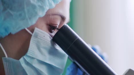 científico mirando a través de un microscopio