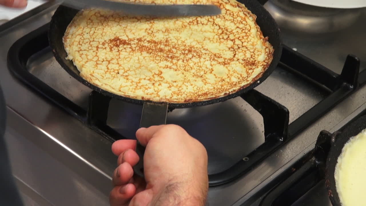 slomo: toma de un cocinero haciendo panqueques en una estufa