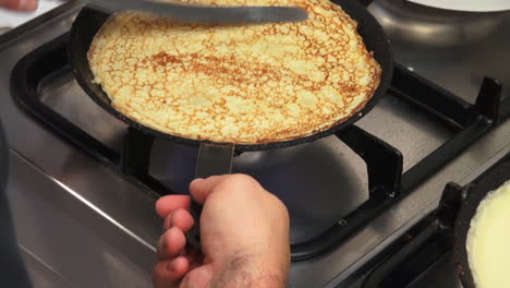 slomo: shot of a cook making pancakes on a stove