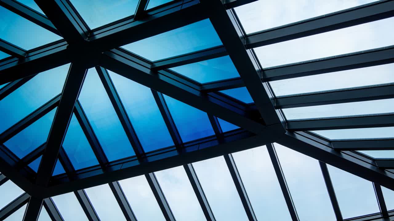 Geometrisk glasert takvindu viser subtil fargeskifting mens tynne skyer passerer, for en lysstudie.