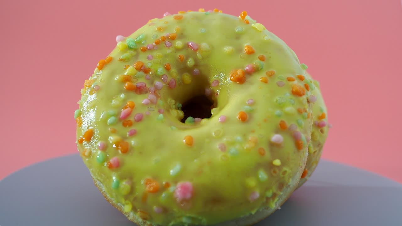 donut de limón fresco sobre un fondo rosado. donut de lemón