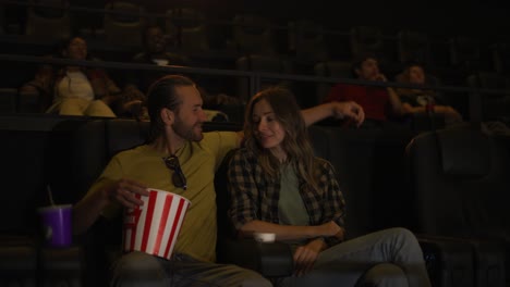 couple have a date at the cinema, sitting embracing