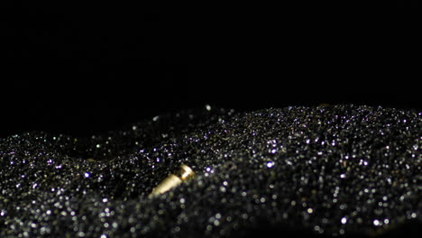 gun bullets falling into the black powder granules
