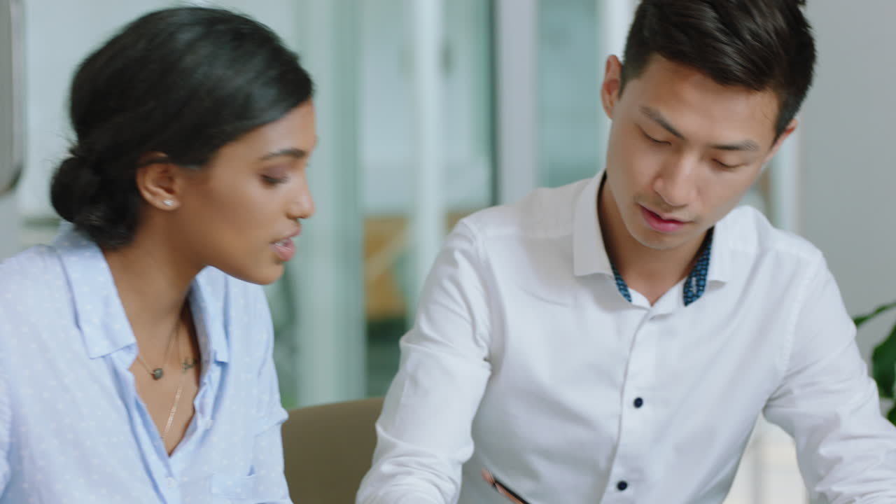 hermosa mujer de negocios líder de equipo entrenando pasante asiático escribiendo notas mujer ejecutiva compartiendo ideas enseñando colega en la oficina 4k