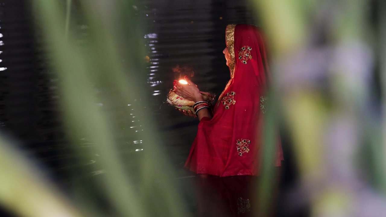 Mulher Hindu Realizando o Ritual Chhath Puja Com Lâmpada de Barro em Rio Sagrado, imagem capturada no festival Chhath