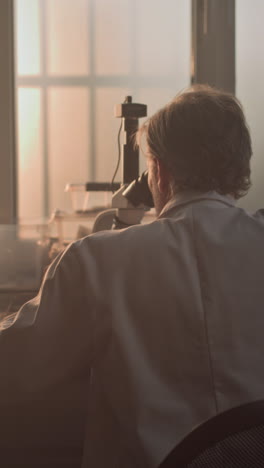 scientist working on microscope in a lab