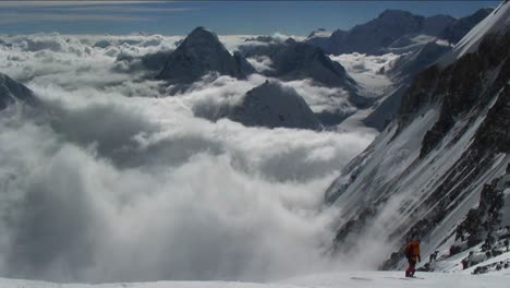 Climber-crossing-with-clouds-and-cliff-in-back