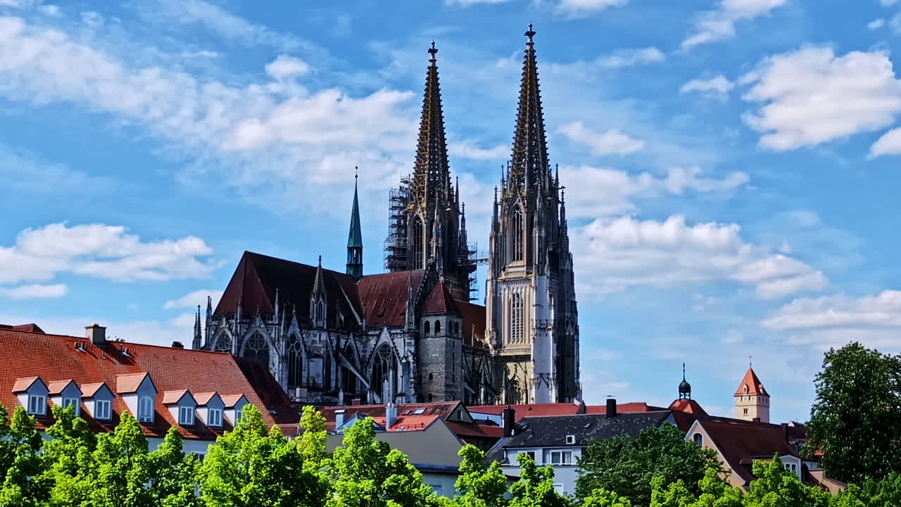 Twin spires of St. Peter’s Cathedral rising above red rooftops in Regensburg, Germany