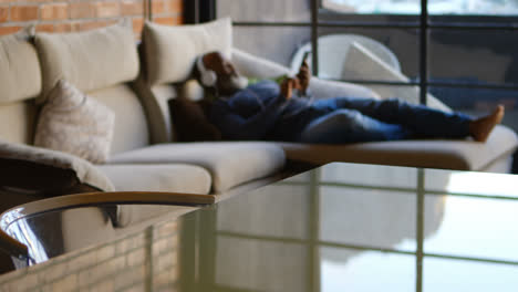 senior man listening music on mobile phone in living room 4k