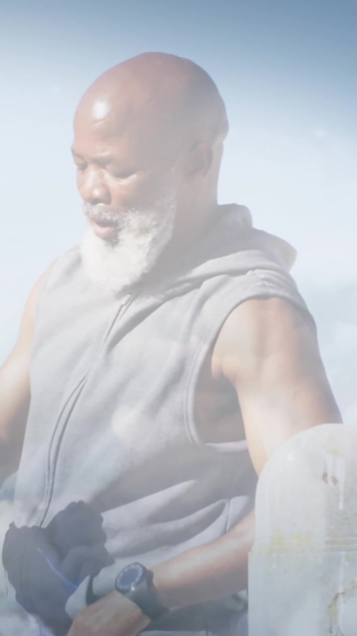 Animation of glowing lights over fit senior man drinking water during exercise and clouds background