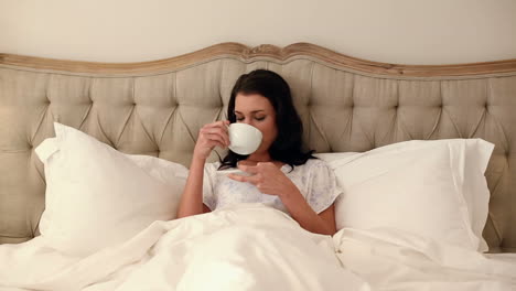 Schöne-Brünette-Liegt-Im-Bett-Und-Trinkt-Kaffee