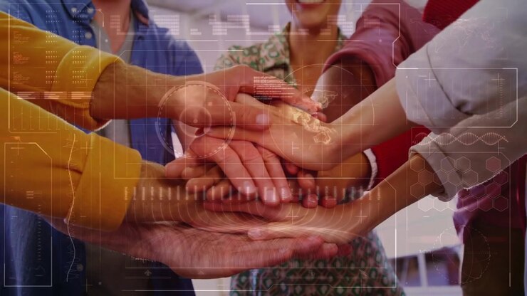 Manica color senape che estende il palmo, una squadra che unisce le mani, impilandole e toccandole per simboleggiare l'unità, con sovrapposizione HUD.