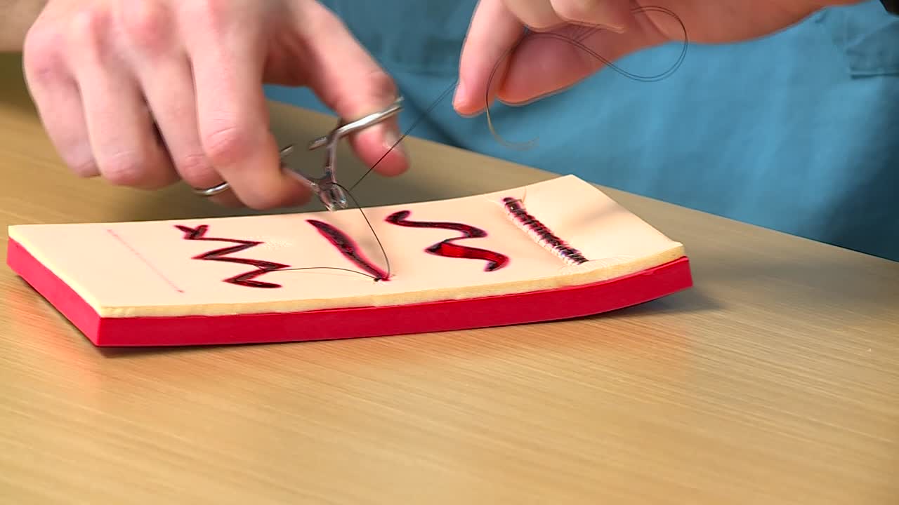 enfermera o médico que practica la sutura