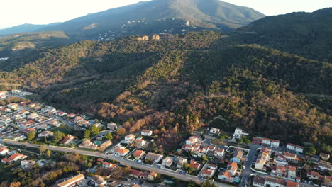 aerial view of a town nestled in a valley, surrounded by mountains and forests.