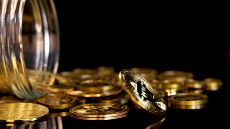 gold cryptocurrency coin spins and falls among scattered tokens, dramatic lighting, black reflective background
