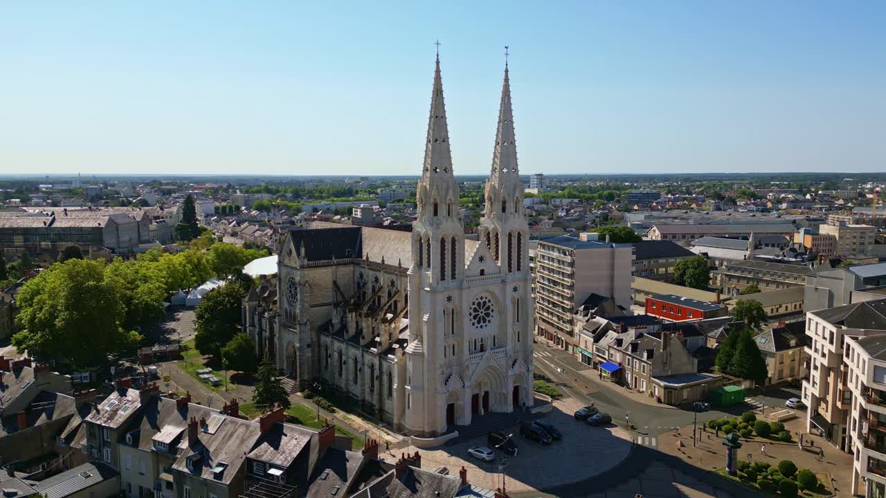 Saint Andrew Church in Chateauroux with city buildings surrounding and spires reaching skyward, aerial medium orbit establish