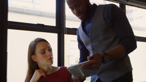 Front-view-of-young-cool-mixed-race-business-team-planning-and-working-at-desk-of-modern-office-4k