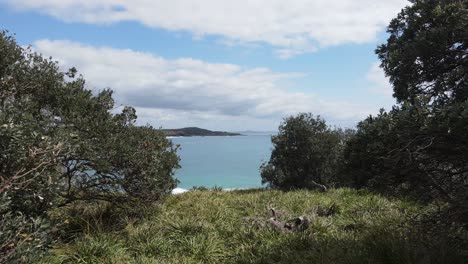 Slowly-walking-along-a-hidden-coastal-headland-to-reveal-a-secret-surfing-break-and-ocean-bay