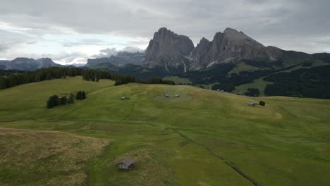 green meadows and idyllic huts meet the imposing sassolungo group in the heart of the italian dolomites