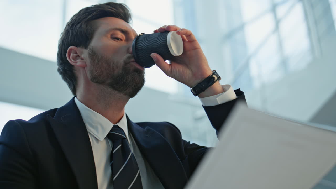 Closeup businessman analyzing documents sitting office staircase with coffee cup