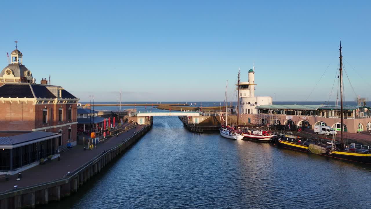 Drone zweeft over het bassin met het ronde gebouw en traditionele boten in beeld.