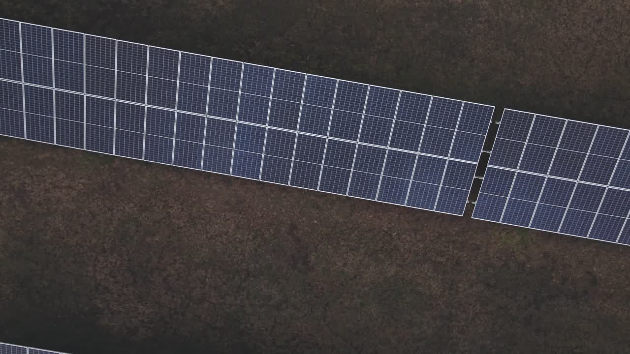 Si eleva sopra un impianto fotovoltaico in cerchio. I pannelli solari sono allineati in una disposizione sistematica.