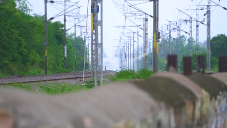 Gente-Cruzando-Peligrosamente-Las-Vías-Del-Tren-En-India-Con-Líneas-Eléctricas-Encima