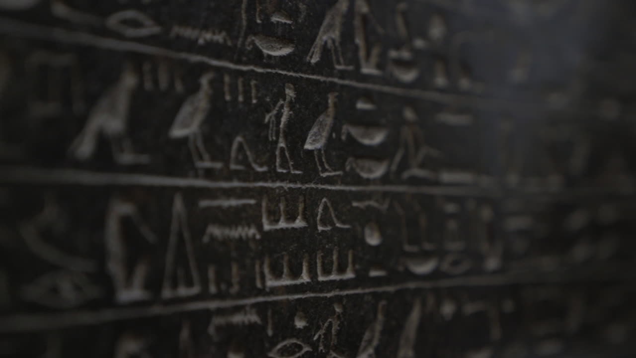 Macro close up of ancient Egyptian hieroglyphics symbols written on wall