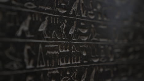 macro close up of ancient egyptian hieroglyphics symbols written on wall
