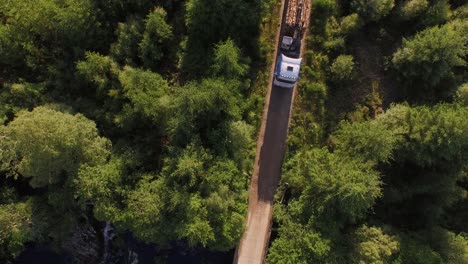 forestry and logging operations taking place in the highlands of scotland using large industrial machinery, ships and trucks