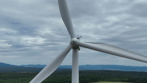 Primer-Plano-De-La-Turbina-Eólica,-Aspas-Giratorias-Bajo-El-Cielo-Nublado,-Concepto-De-Energía-Verde,-Disparo-Estático-De-Drones