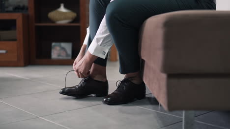 person tying dress shoes indoors