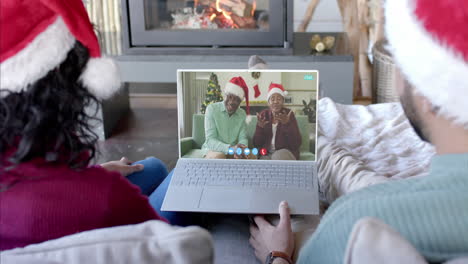 Feliz-Pareja-Diversa-Y-Padres-Mayores-Teniendo-Videollamada-Navideña-Con-Laptop,-Cámara-Lenta