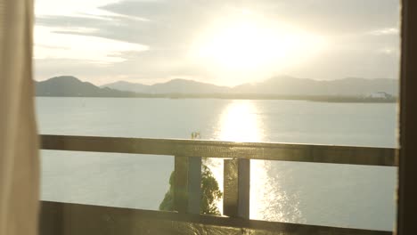 view from balcony resort in phuket seashore with mountain range and sunset over sea