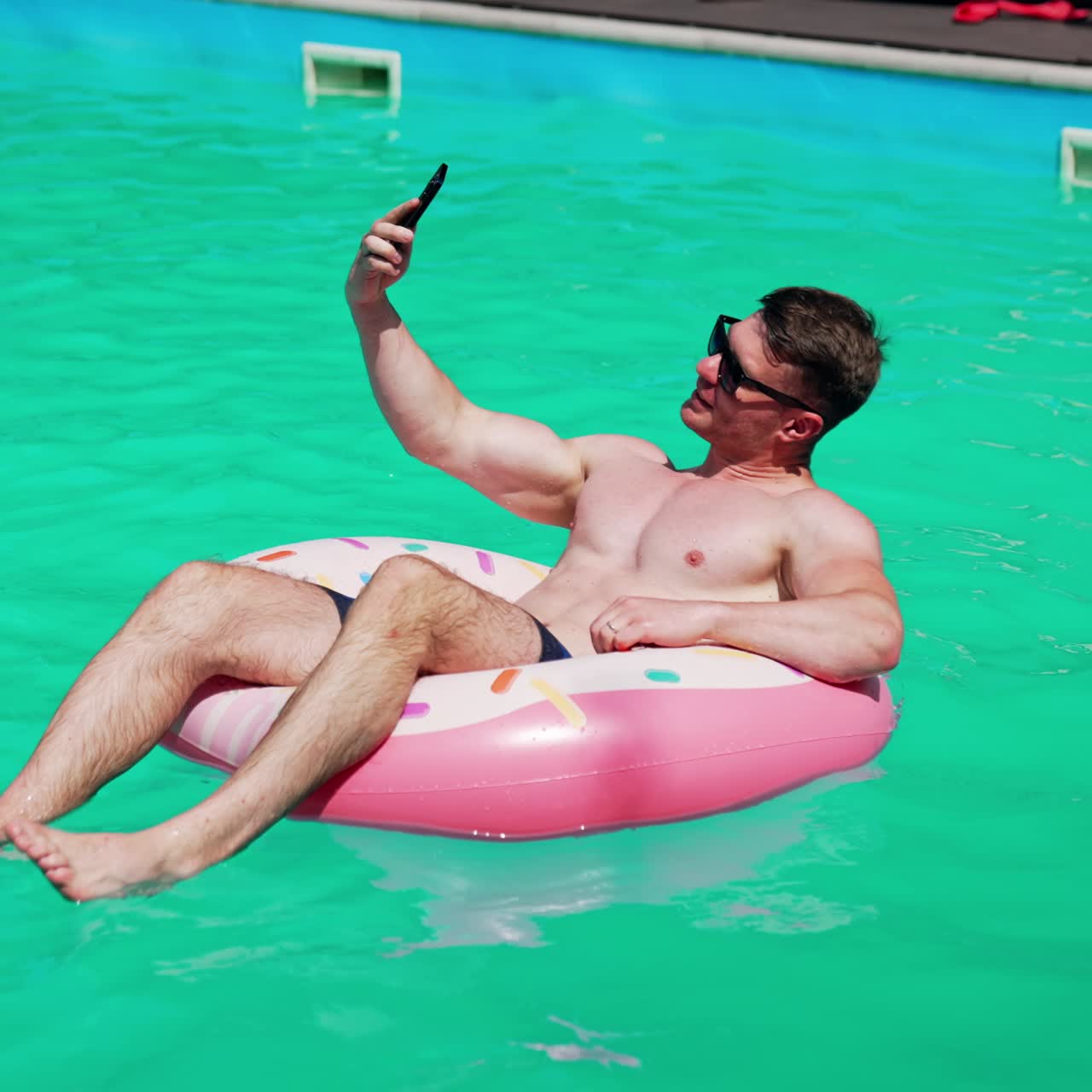 Summertime vaction man in pool having fun. Water fun in sunny summer day