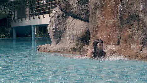 Señora-Descansa-En-La-Piscina-Con-Cascada-Y-Puente-En-Cámara-Lenta