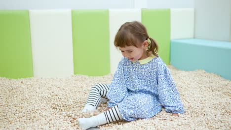 happy child girl plays in sand pit with hinoki wood cubes