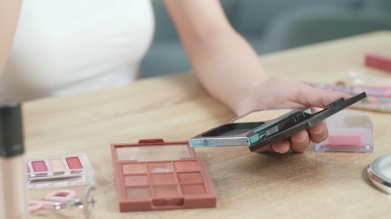 여성 손은 허영에 파우더 얼굴을 들고 집에서 메이크업을 적용하는 데 사용합니다.