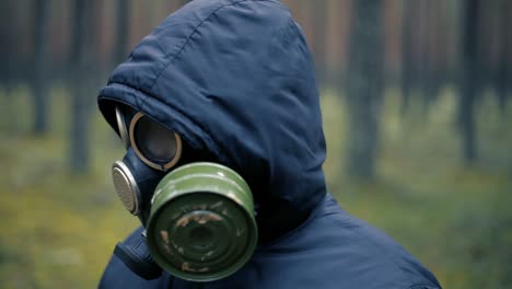 child in pine forest with black gas mask on face