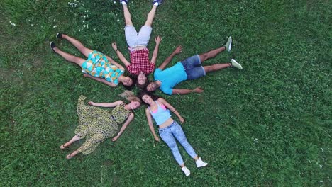 hermosos amigos jóvenes formando una forma de estrella acostados en la hierba