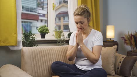 christian woman praying in front of the window.