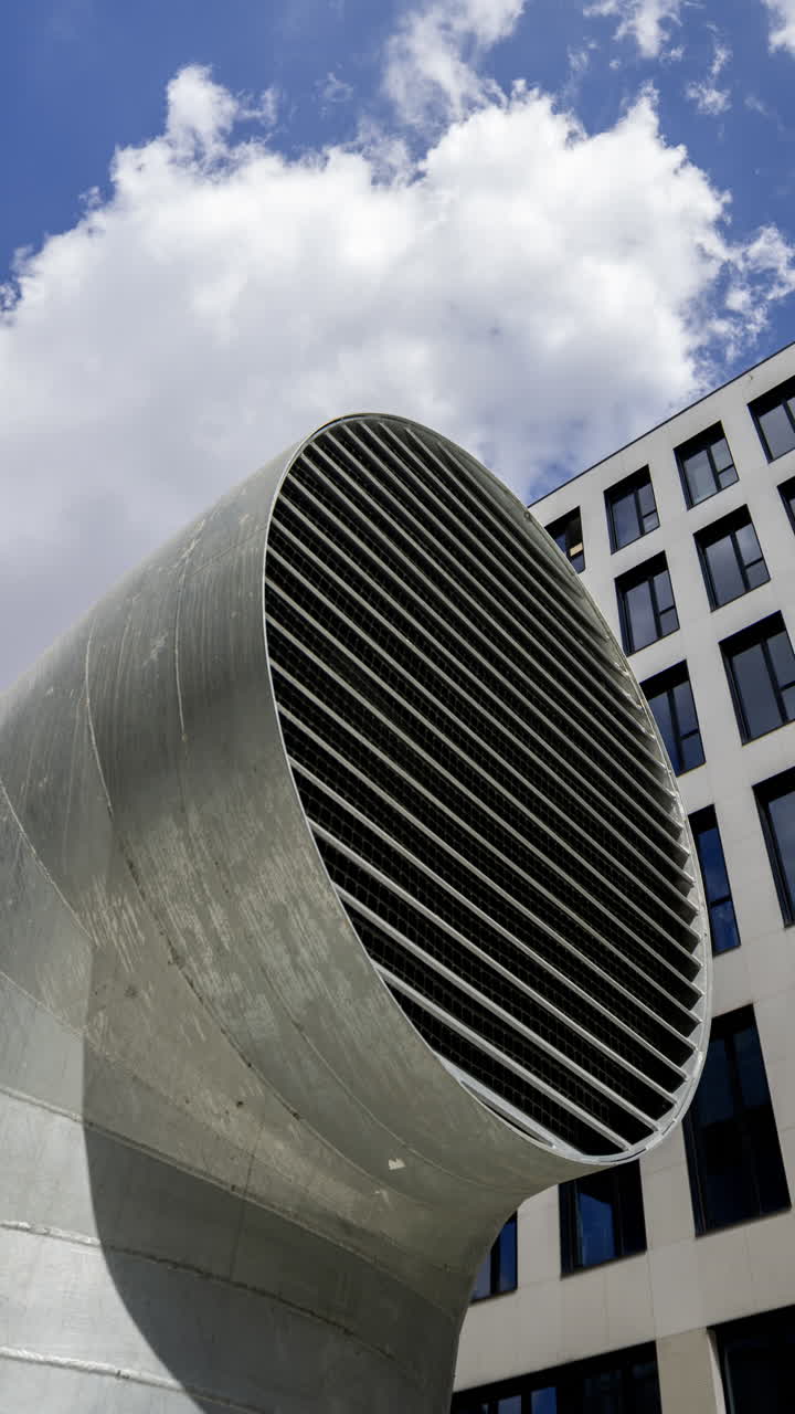 Офисное и промышленное здание с проплывающими облаками в вертикальном формате