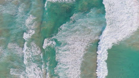 aerial shots of rolling and crashing waves in the ocean