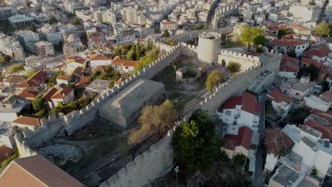 Aerial-view-of-the-city-Kavala-in-Northern-Greece-demonstrating-the-harbour,-the-old-fortress-the-breakwater-and-the-rocky-seasides