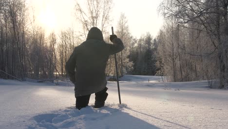 Hombre-Caminando-Con-Raquetas-De-Nieve-A-Través-De-La-Nieve-Profunda-Se-Detiene-Para-Mirar-La-Escena