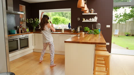 mujer divirtiéndose en la cocina usando auriculares vr