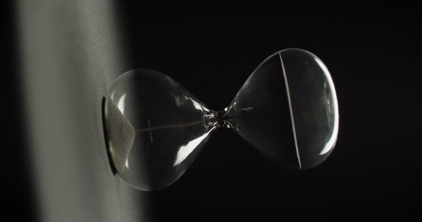 Hourglass rotating on black background