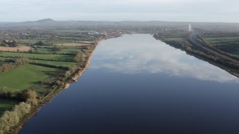 Antenne-Fliegt-über-Breiten,-Glasig-Glatten-Fluss-Inmitten-Ländlicher-Landwirtschaft