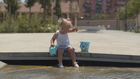 Kleines-Mädchen-Spielt-An-Einem-Heißen-Tag-Im-Brunnen